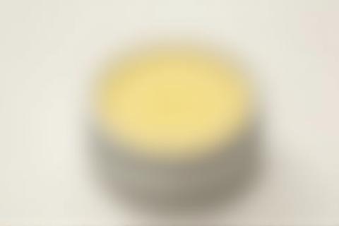 Natural lip balm in a small metal tin, showing smooth texture