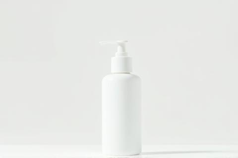 Hand lotion in a minimalist white pump bottle on a simple surface